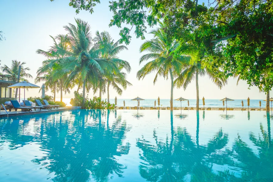 All-Inclusive-Resort mit Infinity-Pool und Palmen bei Sonnenuntergang