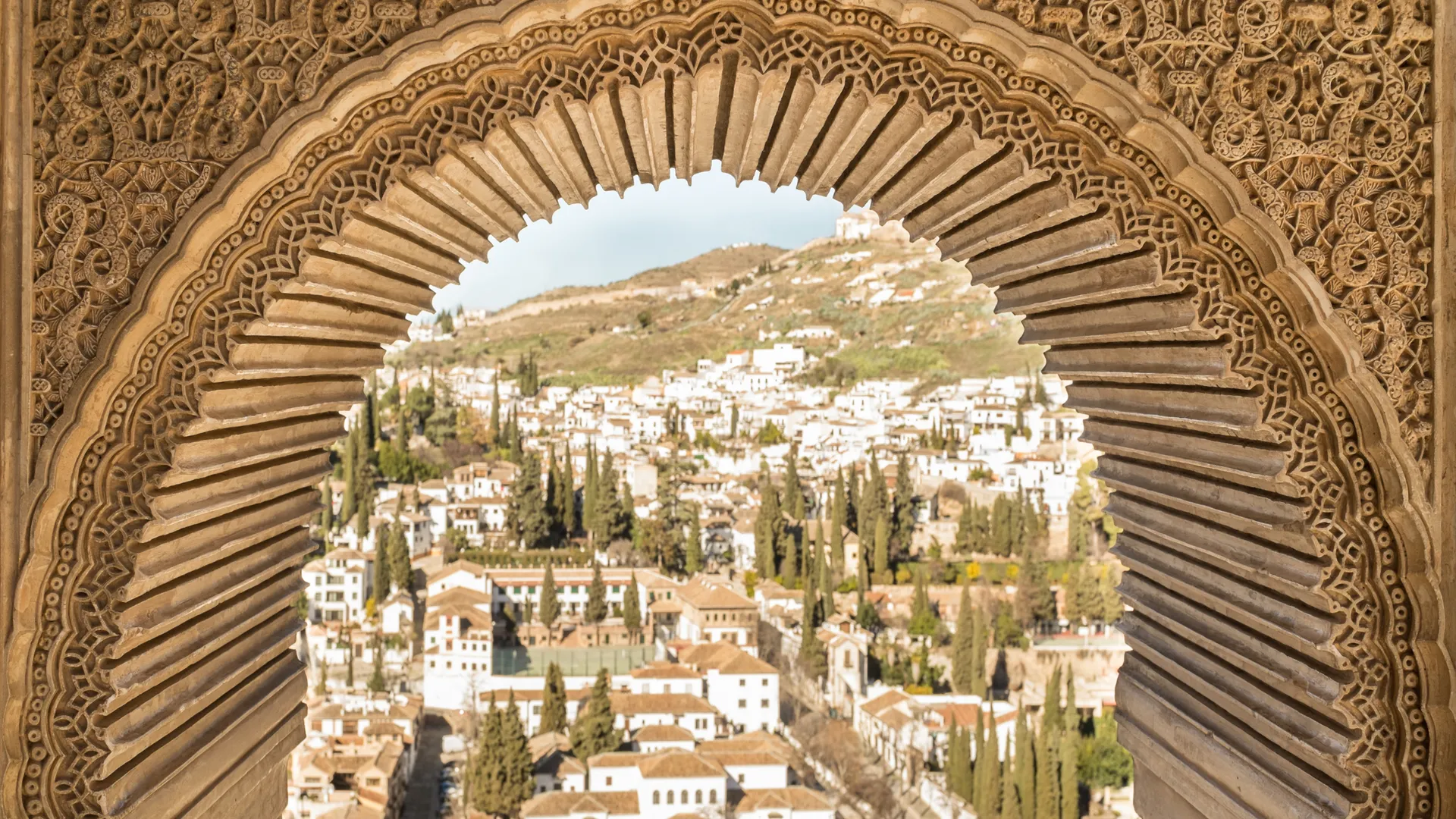 Blick durch einen maurischen Bogen auf die Alhambra in Granada