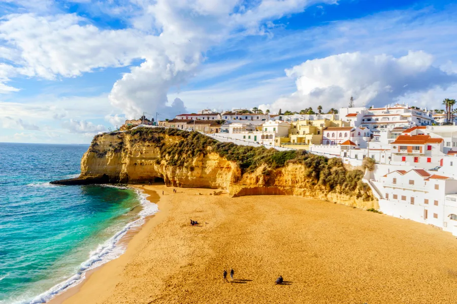 Strand von Carvoeiro mit goldenen Klippen und weißen Häusern an der Algarve, Portugal