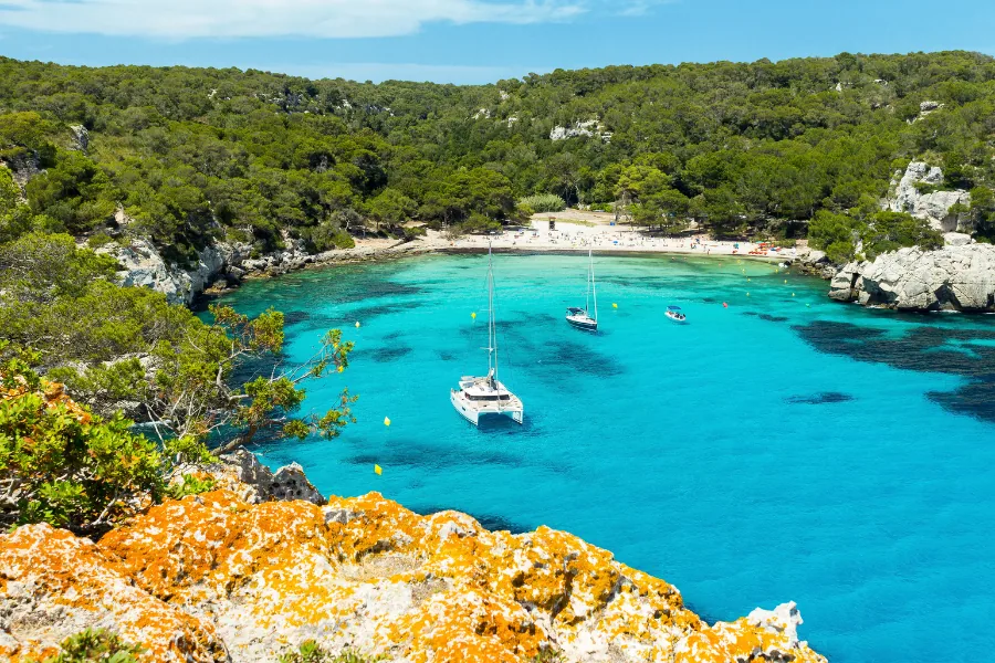 Türkise Bucht Cala Macarella auf Menorca mit Booten, Spanien