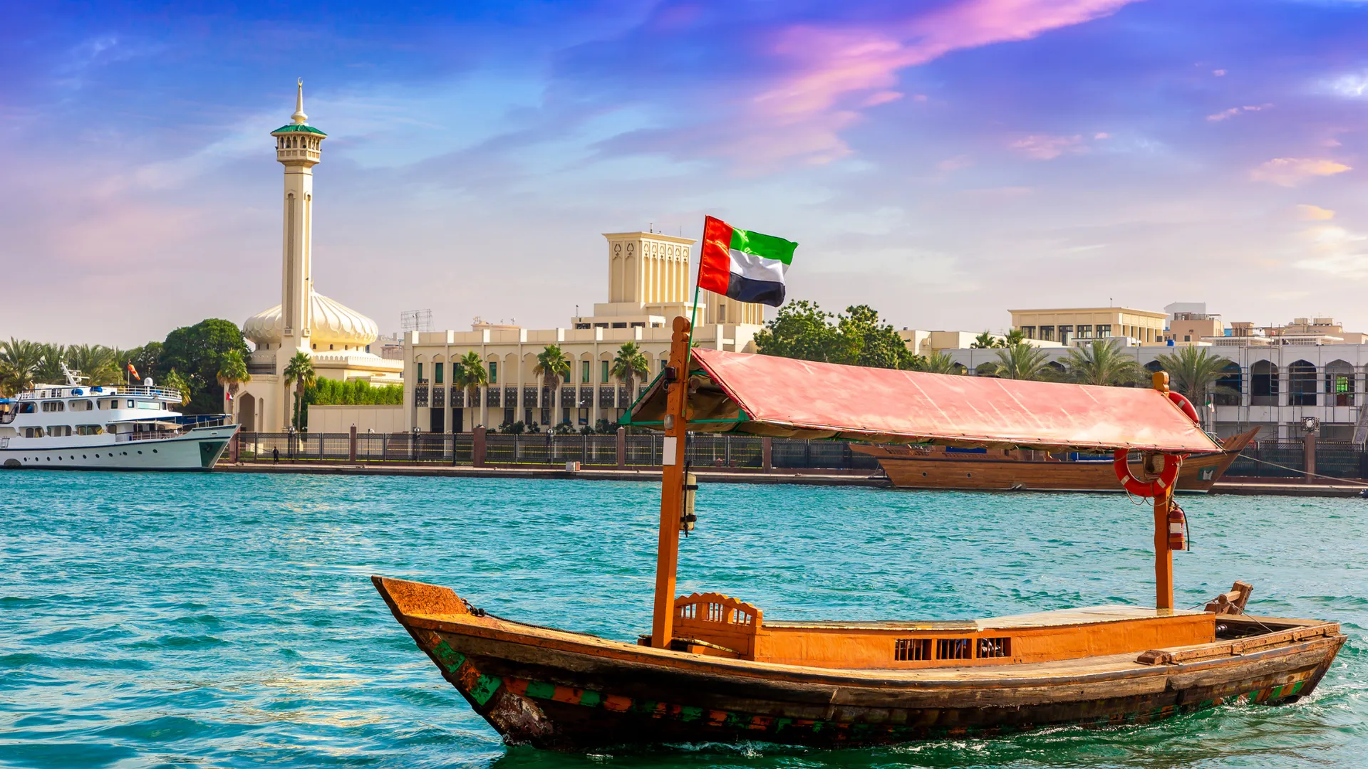 Traditionelle Abra-Boote auf dem Dubai Creek mit Skyline im Hintergrund