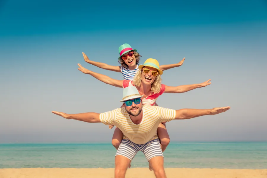 Fröhliche Familie mit Kindern am Strand – Familienurlaub last minute mit Star Reisen