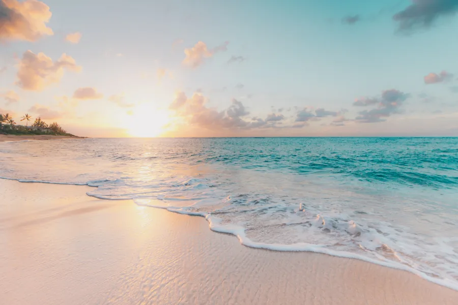 Traumstrand bei Sonnenuntergang mit türkisem Meer – Last-Minute-Reiseziele bei Star Reisen