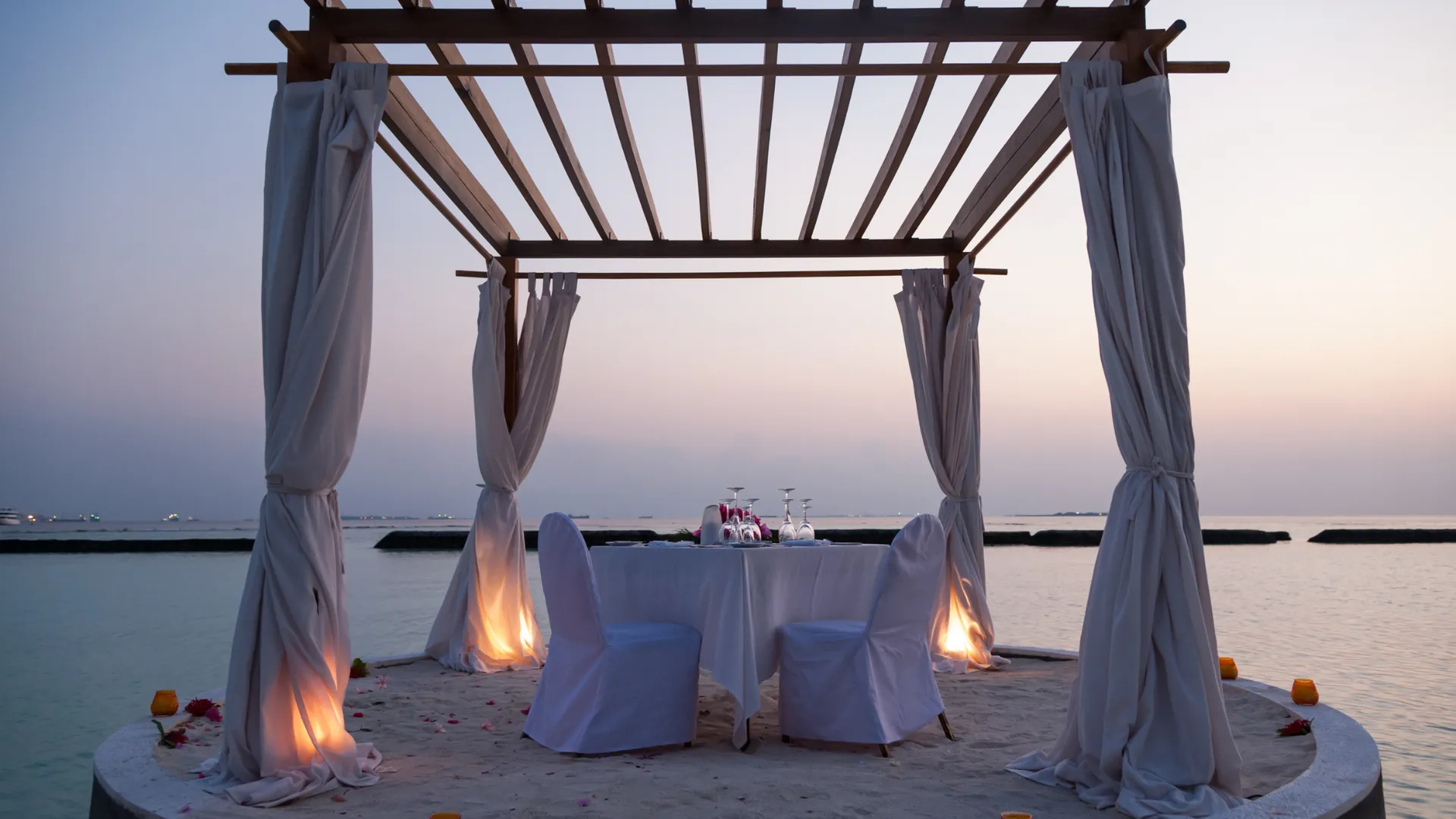 Private Dinner-Cabana am Strand bei Dämmerung