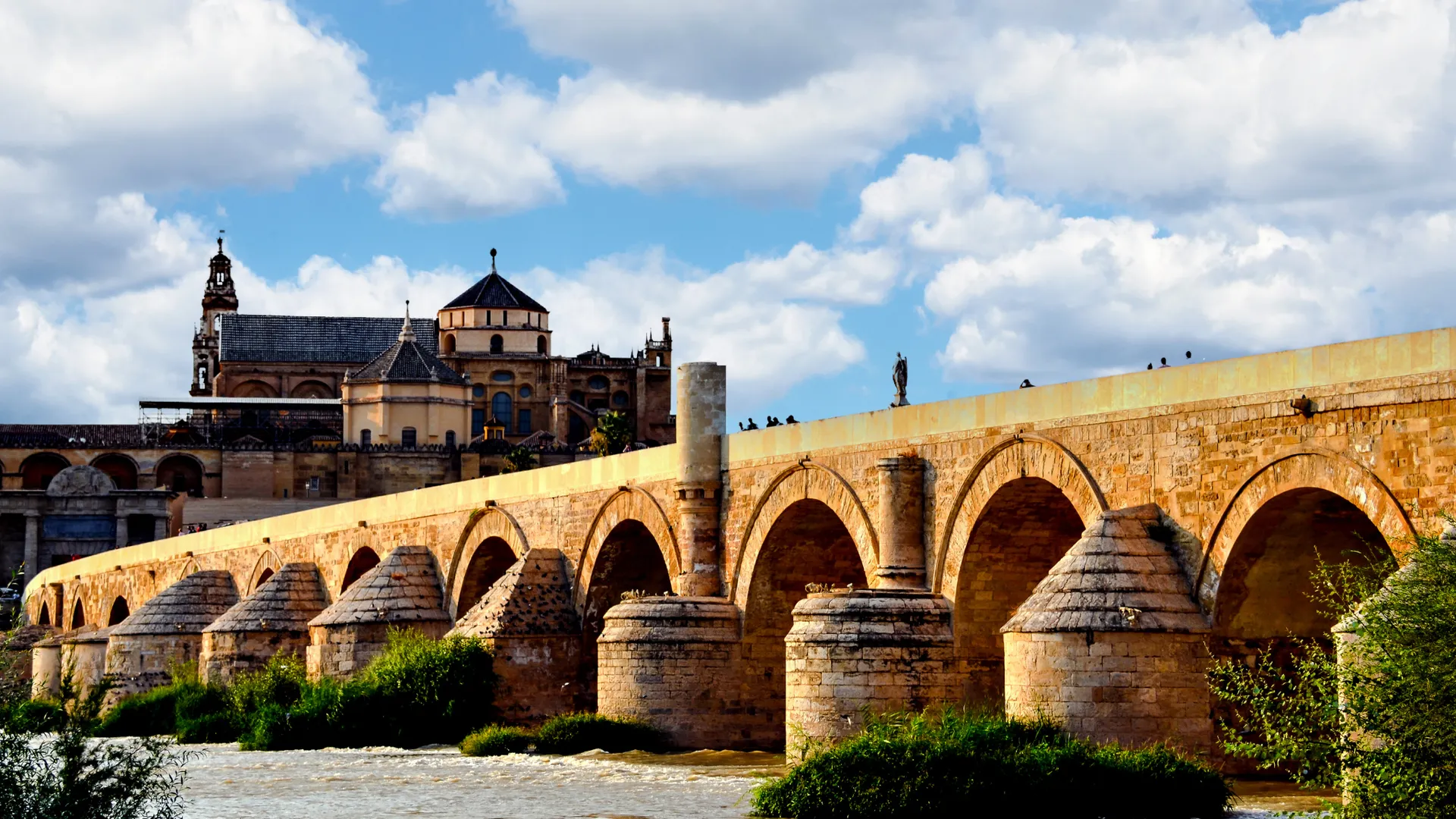Römische Brücke in Córdoba mit Blick auf die Mezquita-Kathedrale bei blauem Himmel